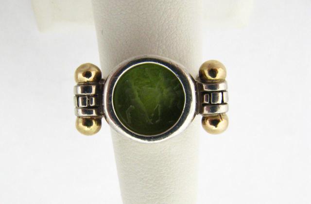 Appraisal: Sterling silver and K yellow gold cared green stone ring