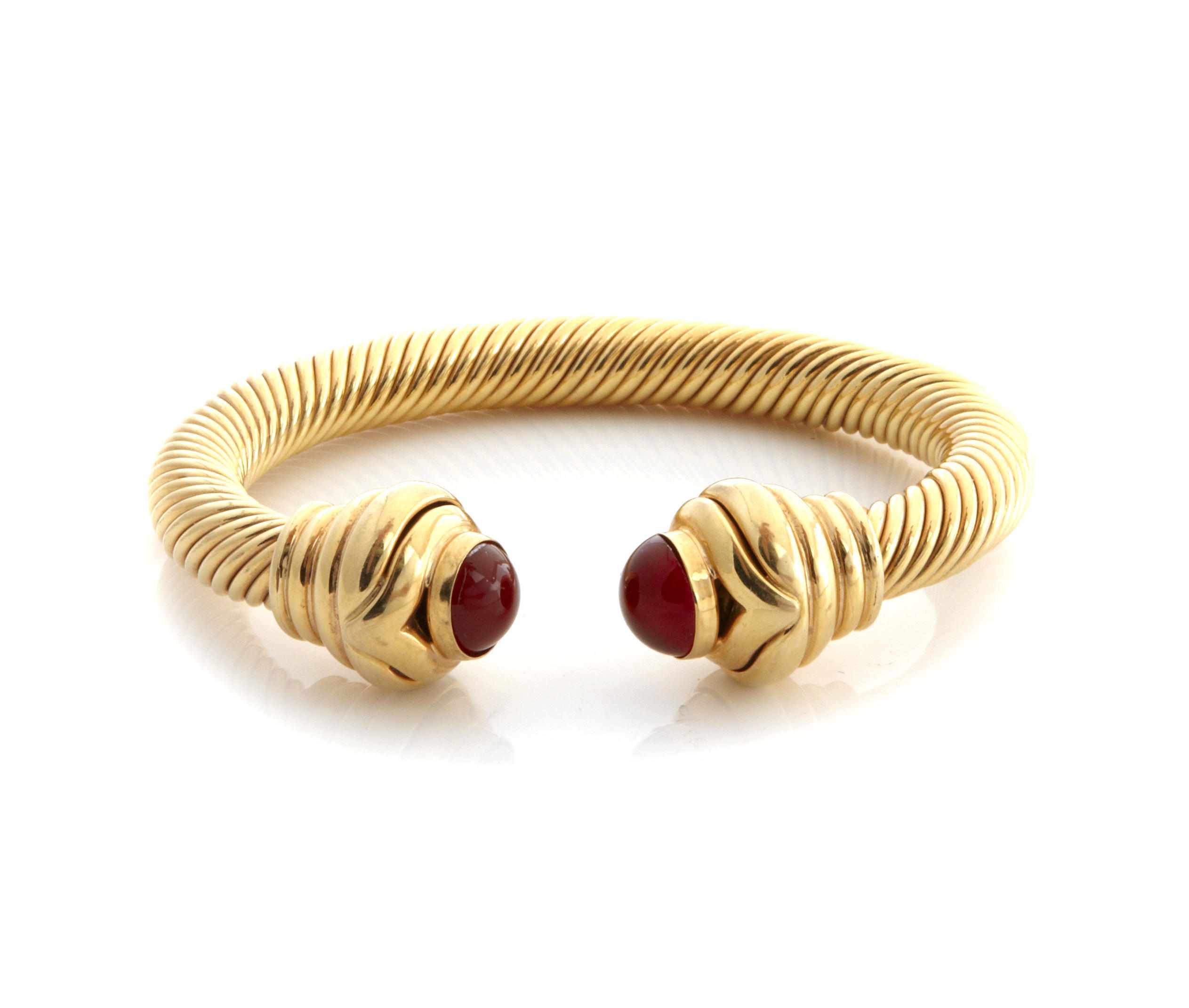 Appraisal: A k gold coil bangle with carnelian terminals diameter in