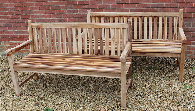 Appraisal: A PAIR OF TEAK GARDEN BENCHES with horizontal backs wide