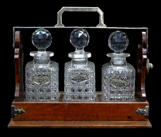 Appraisal: Three-decanter tantalus late th C Betjemann's of London rectangular oak