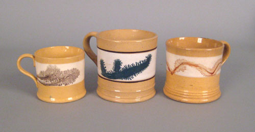 Appraisal: Three yelloware mugs th c with seaweed decoration h h