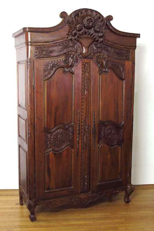 Appraisal: PROFUSELY CARVED ARMOIRE Floral motif crest with carved panels on