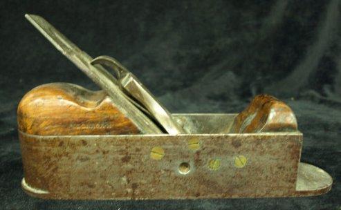 Appraisal: A burnished steel smoothing plane with fruitwood mounts