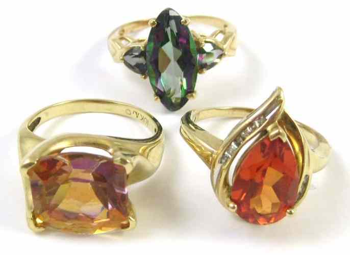 Appraisal: THREE TEN KARAT GOLD RINGS including an orange sapphire and