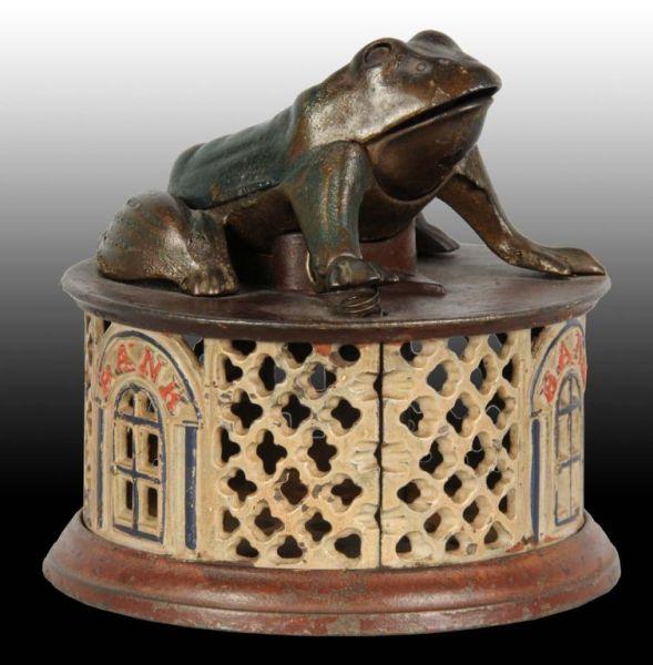 Appraisal: Cast Iron Frog on Lattice Mechanical Bank Description Manufactured by