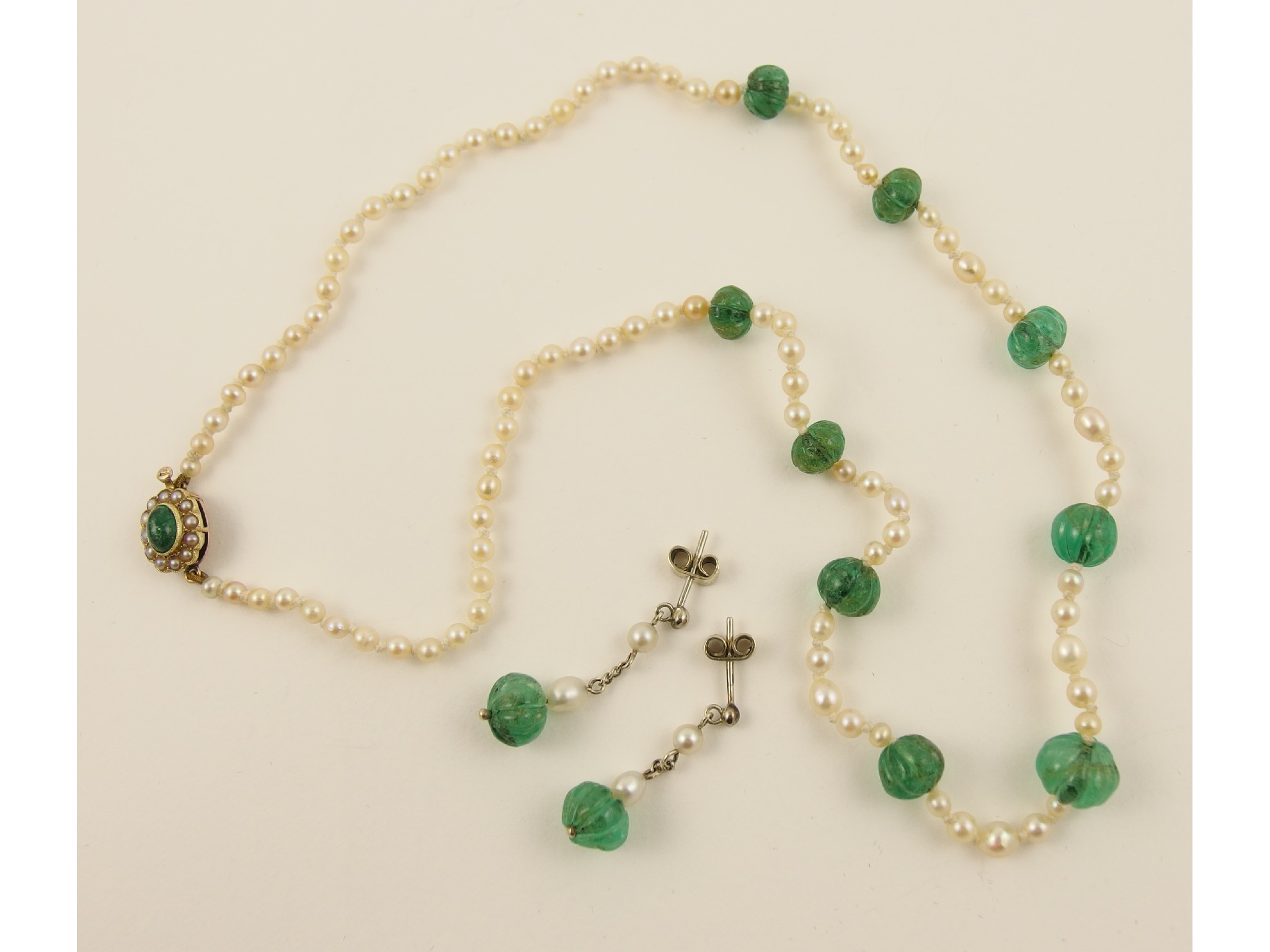 Appraisal: A string of pearls with carved emerald beadsthe pearls of