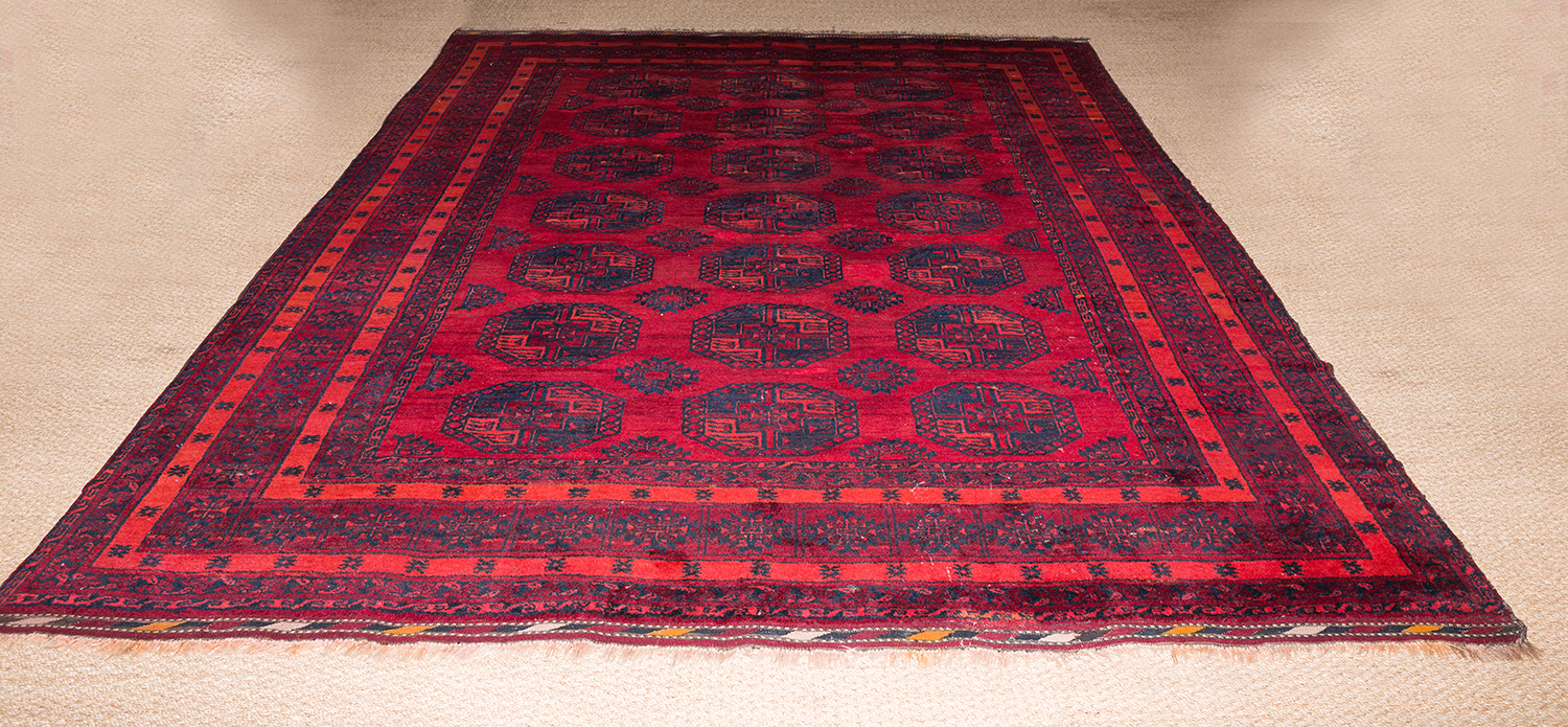 Appraisal: AN AFGHAN TRIBAL RUG IN BURGUNDY TONES x cm