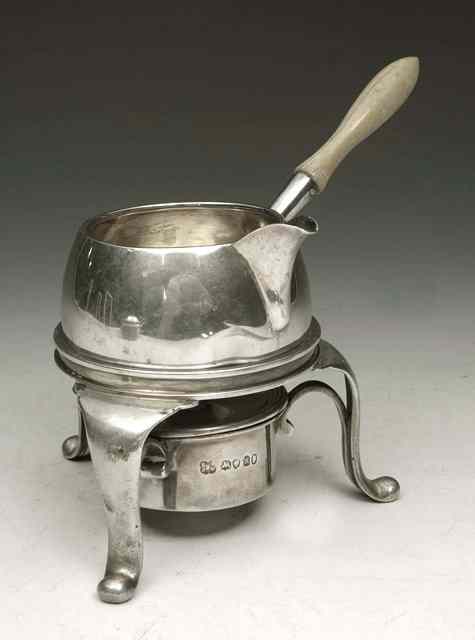 Appraisal: A SILVER BRANDY WARMER tripod stand with cabriole legs and