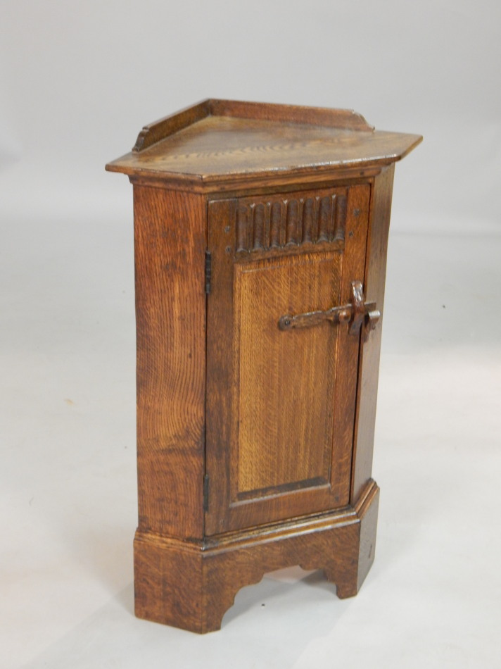 Appraisal: A small oak standing corner cabinet with a raised back