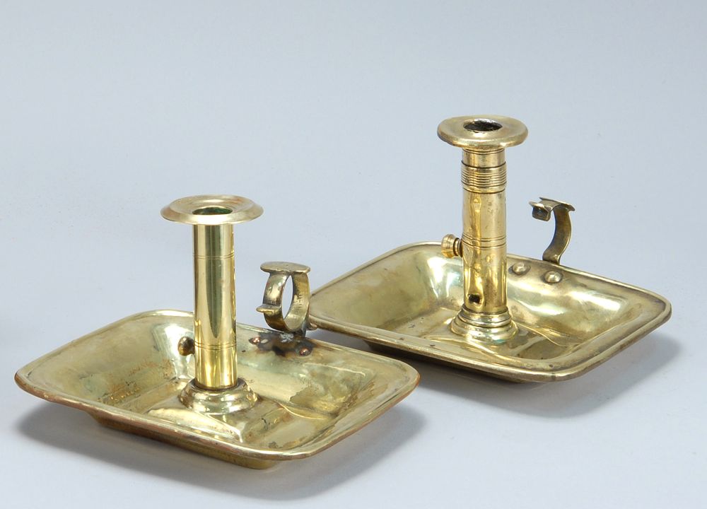 Appraisal: TWO BRASS PUSH-UP CHAMBERSTICKS American Mid- th CenturyWith rectangular saucer