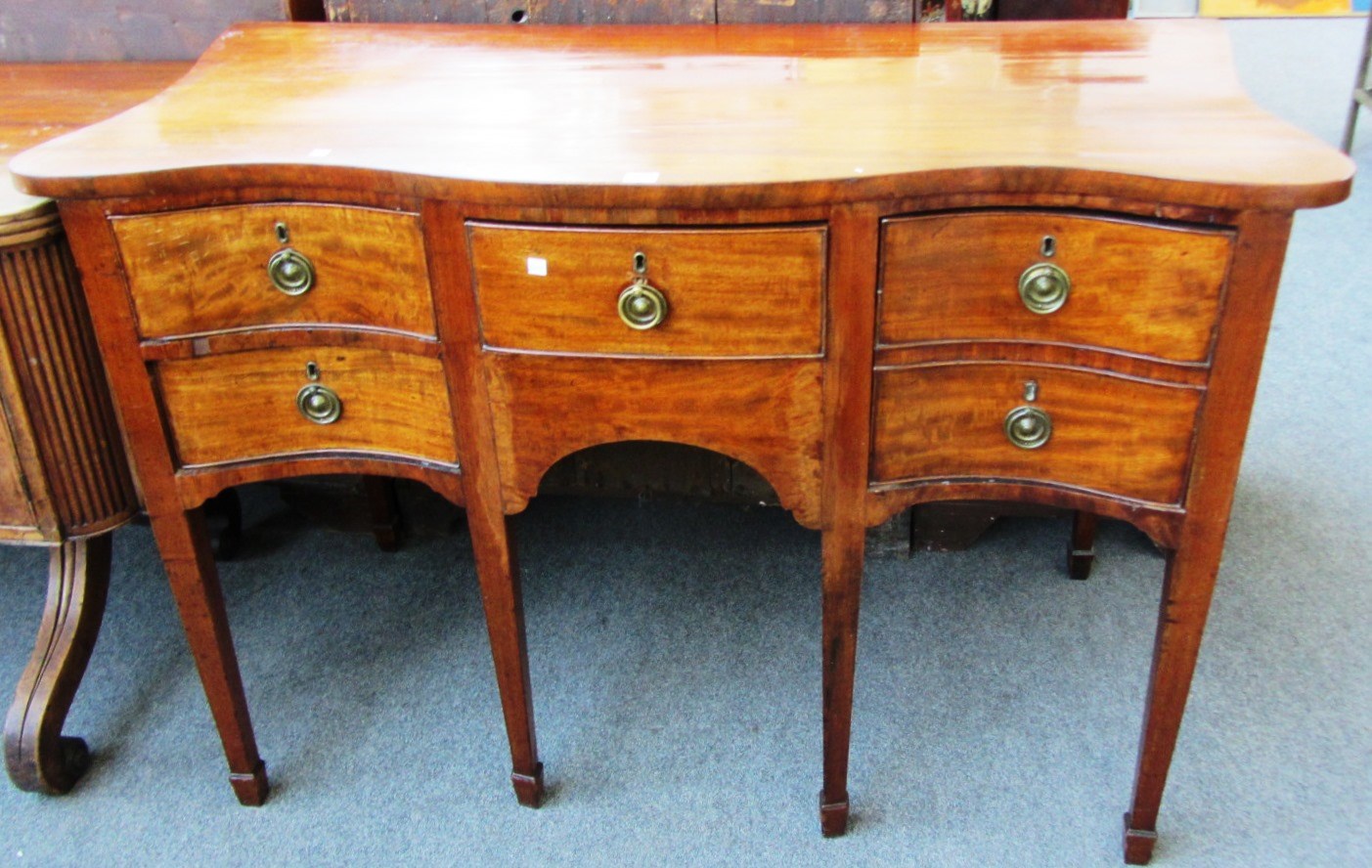 Appraisal: A George III mahogany serpentine sideboard with four frieze drawers