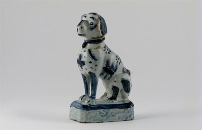 Appraisal: A Delft model of a dog seated on a rectangular