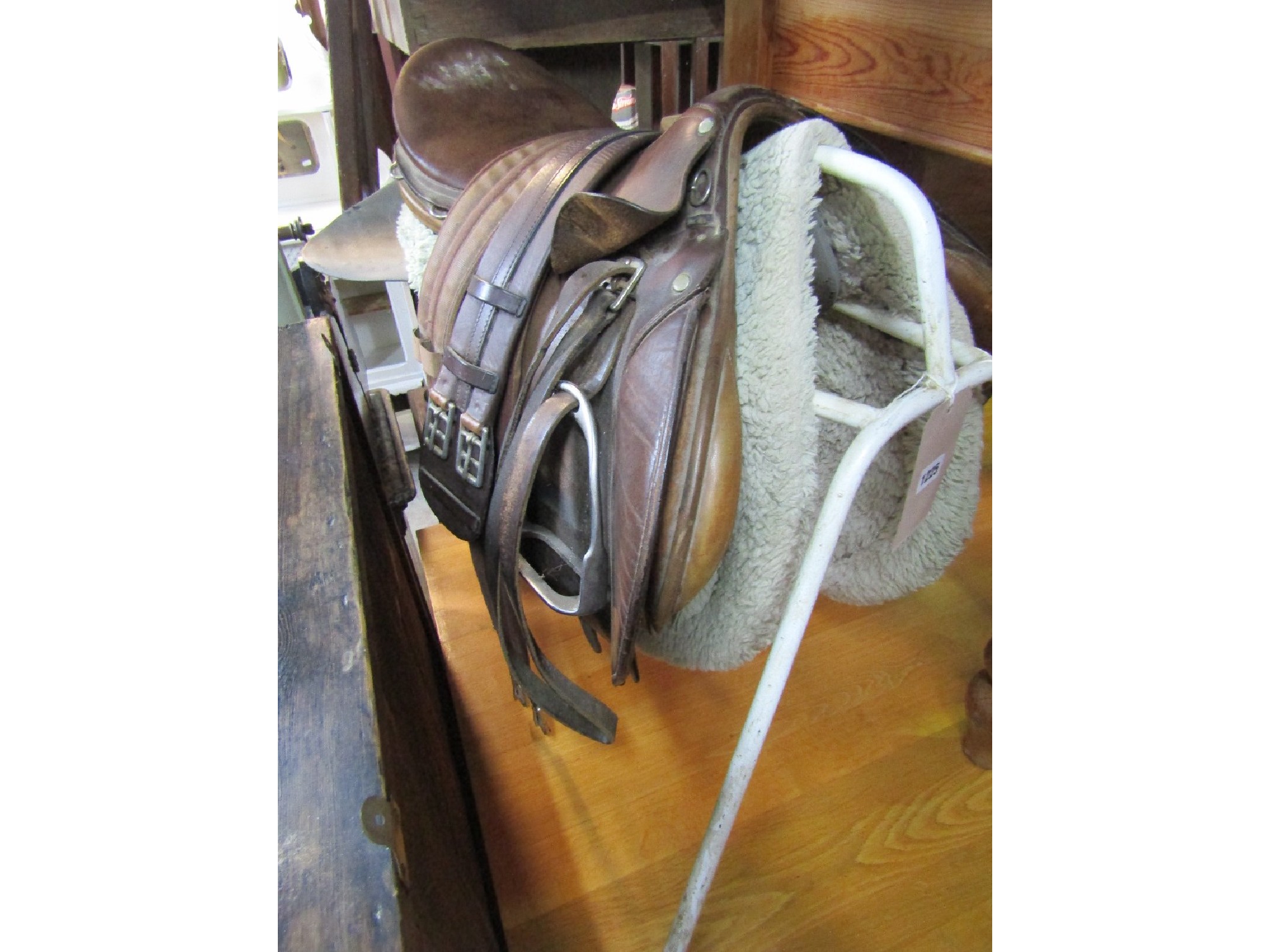 Appraisal: A tan leather equestrian saddle complete with stirrups and selection