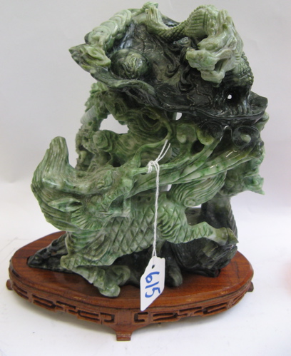 Appraisal: CHINESE JADE FIGURAL CARVING AND STAND The group of ferocious