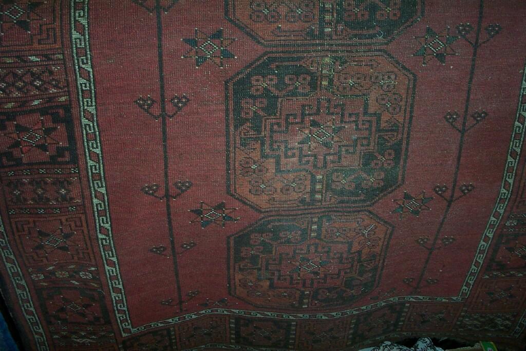 Appraisal: A red ground Eastern wool rug with repeating geometric and