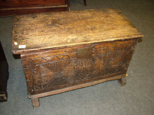 Appraisal: A pine coffer the solid top above relief carved front