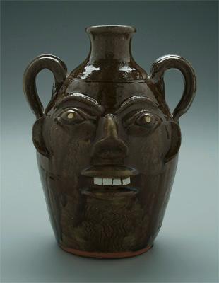 Appraisal: Walter Fleming double face jug runny medium to dark olive