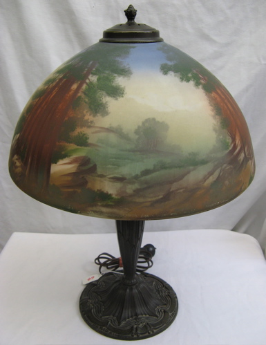 Appraisal: A PAINTED GLASS SHADE TABLE LAMP of a forested scene