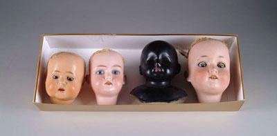 Appraisal: FOUR DOLL HEADS One glass eyed celluloid - cracks coming