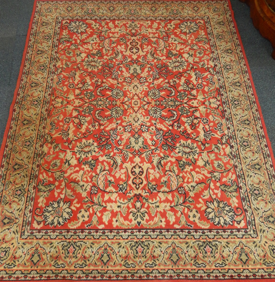 Appraisal: A Caucasian rug decorated with floral motifs against a red