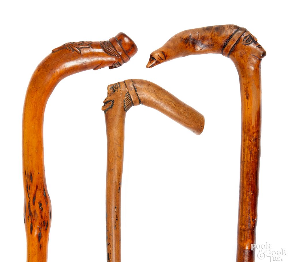 Appraisal: Three carved canes Three carved canes with face grips Condition