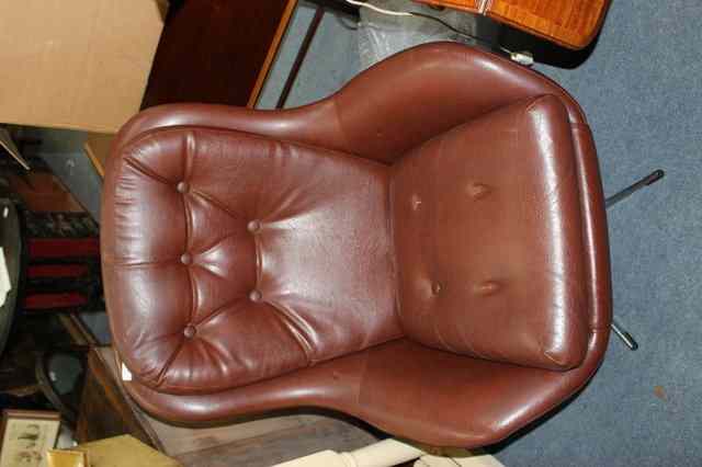 Appraisal: A STYLISH BROWN LEATHERETTE UPHOLSTERED CHAIR with buttoned cushions and