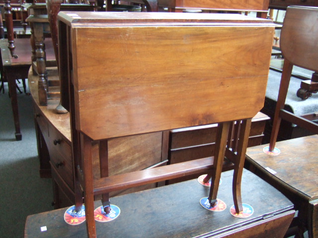 Appraisal: An Edwardian walnut Sutherland table the canted top raised on