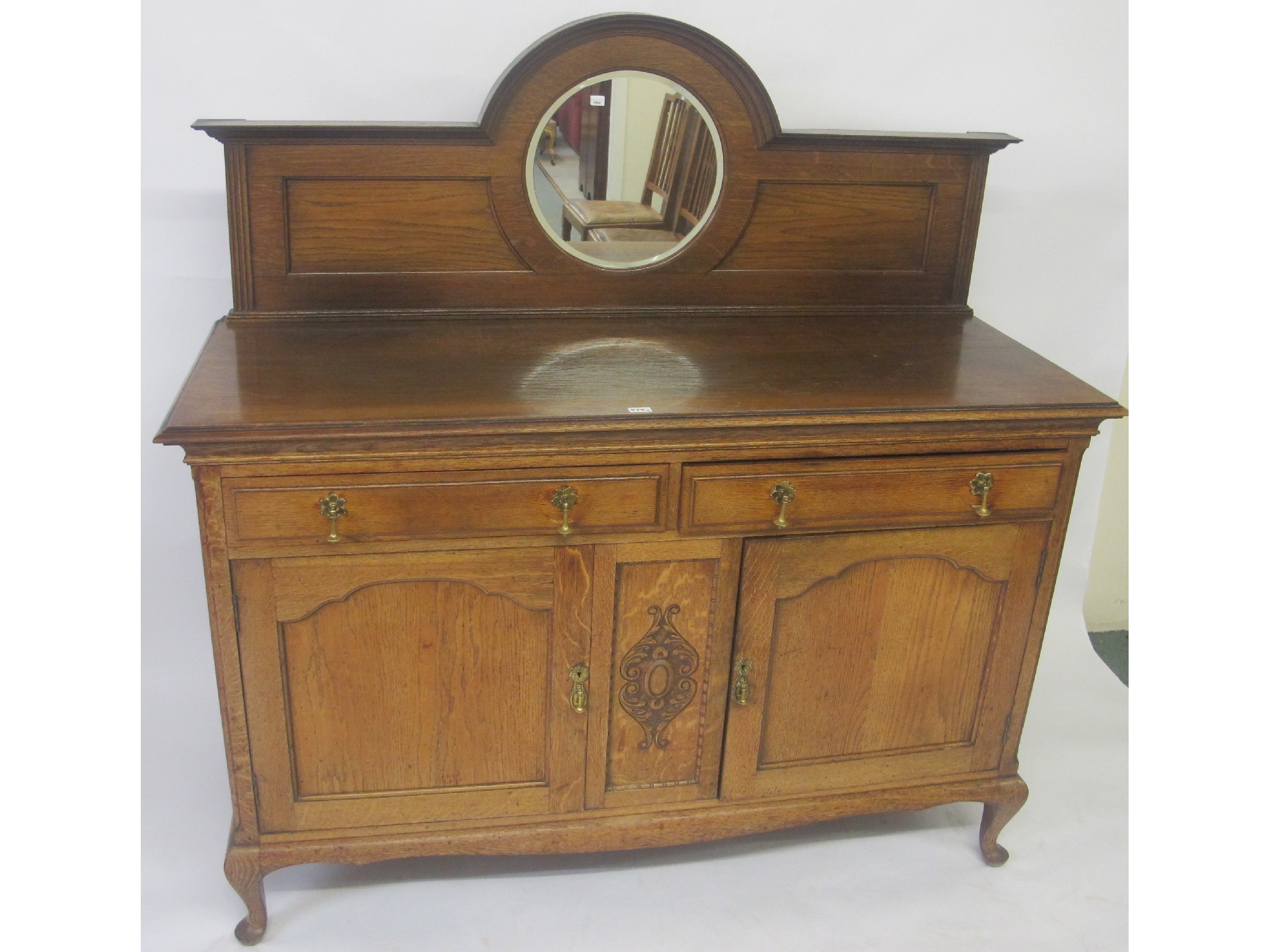 Appraisal: An oak mirrored back sideboard