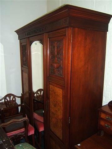 Appraisal: A Victorian walnut triple wardrobe with central mirrored door flanked