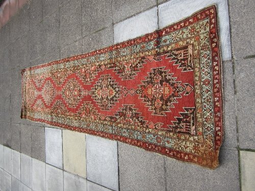 Appraisal: An Oriental rug with five serrated brown floral medallions on