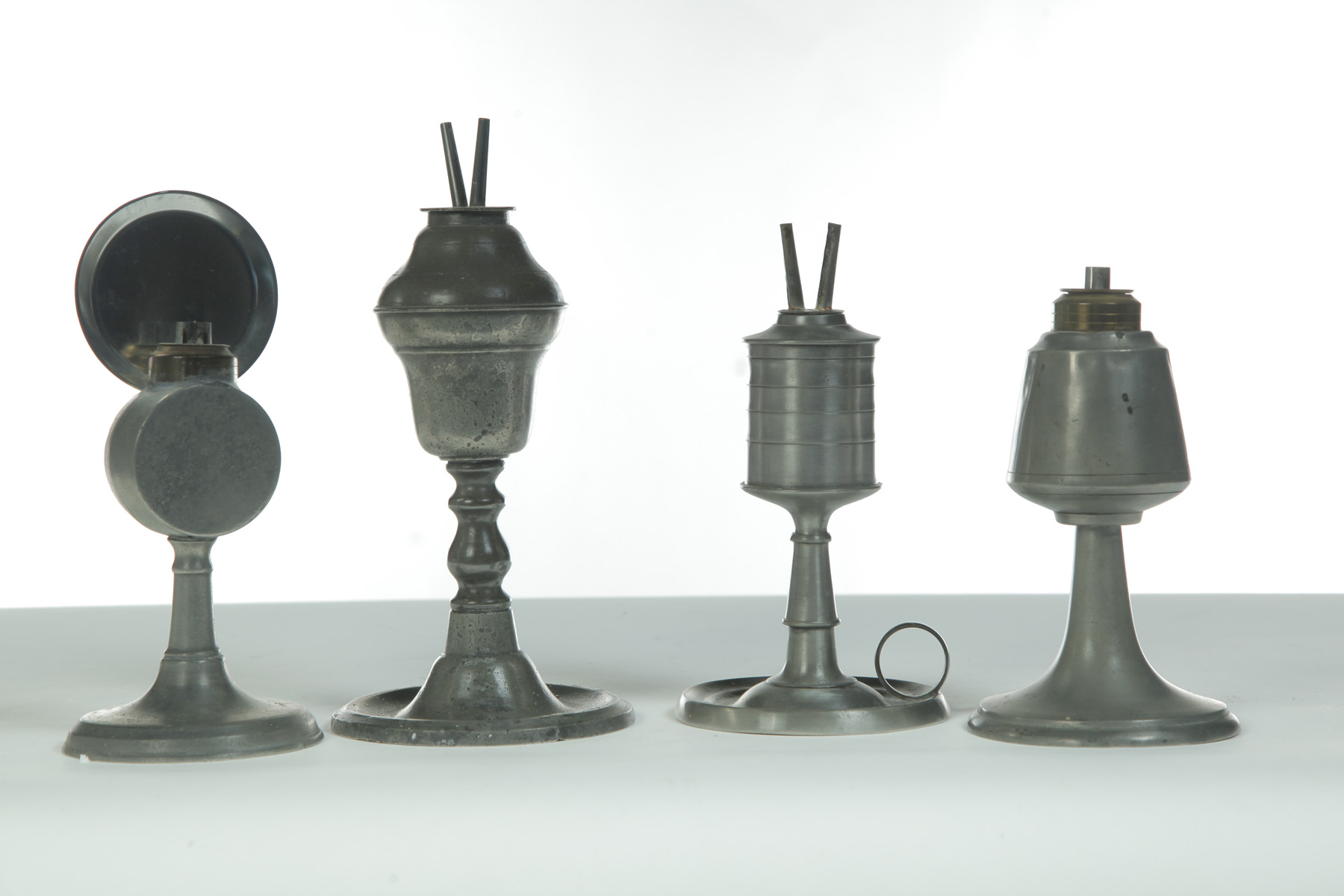 Appraisal: FOUR PEWTER FLUID LAMPS American st quarter th century Whale