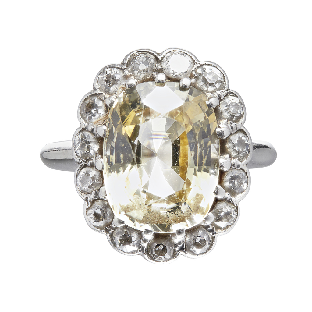 Appraisal: A yellow sapphire and diamond cluster ring claw set with