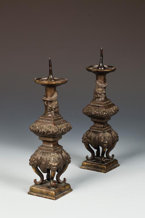 Appraisal: A PAIR OF CHINESE BRONZE ALTAR CANDLESTICKS with square-section baluster