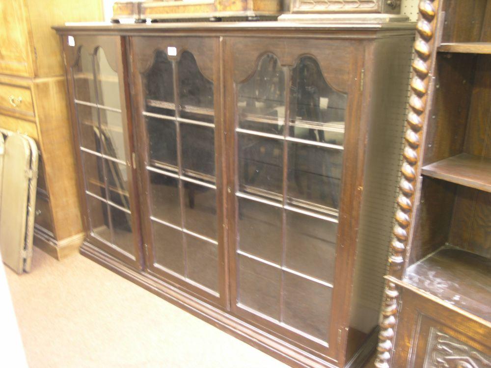 Appraisal: A dark mahogany bookcase enclosed by two astragal glazed doors