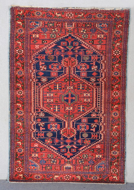 Appraisal: A PERSIAN RED GROUND RUG with a central diamond motif