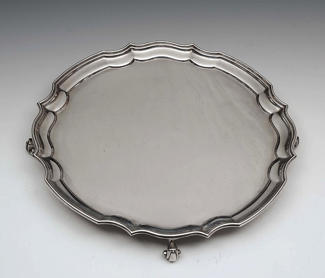 Appraisal: A SILVER SALVER with Chippendale border and four scrolled feet