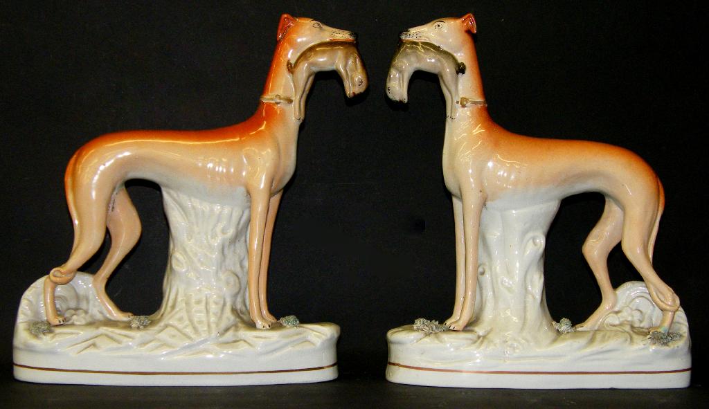 Appraisal: Pair of Victorian Staffordshire greyhounds standing with rabbits in their