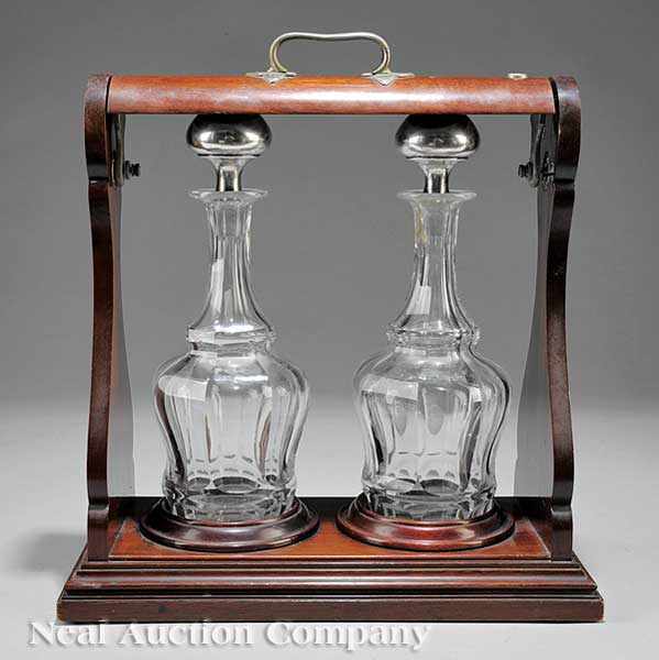 Appraisal: An Edwardian Mahogany Tantalus the open handled case with a