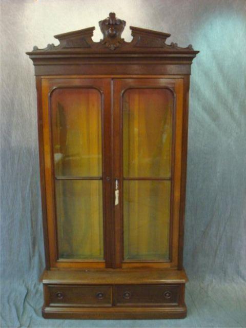 Appraisal: Victorian walnut bookcase Two doors over drawers with carved crown