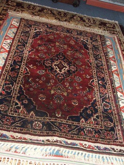 Appraisal: A PERSIAN STYLE DARK RUST GROUND RUG - decorated a