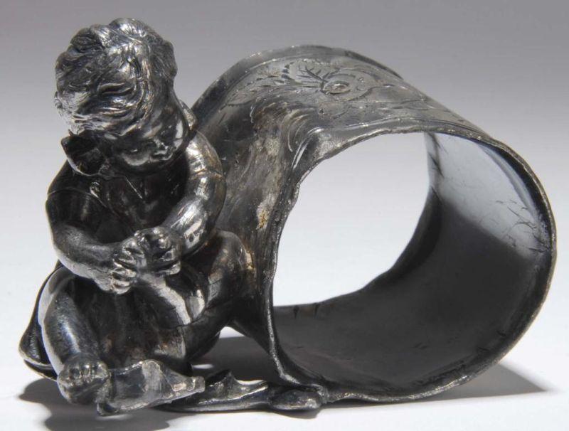 Appraisal: Boy Removing His Socks Figural Napkin Ring Description A little