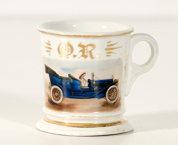 Appraisal: OCCUPATIONAL SHAVING MUG OF A BLUE CAR Porcelain polychrome painted