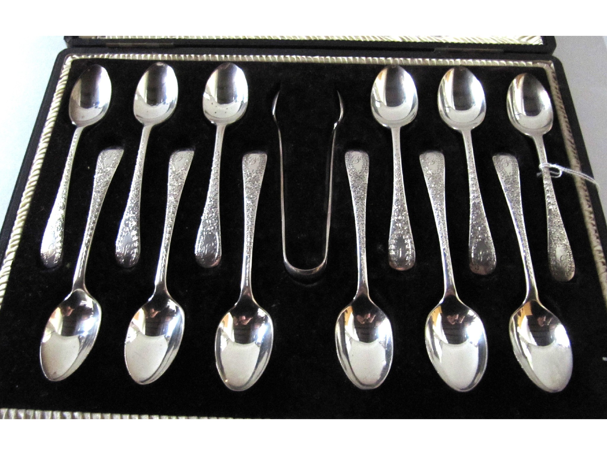 Appraisal: A cased set of twelve silver spoons with tongs Sheffield