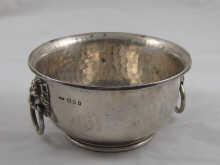 Appraisal: A hand beaten silver bowl with lion mask handles retailed