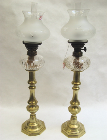 Appraisal: TWO BRASS AND GLASS PEG LAMPS the tall brass candlesticks