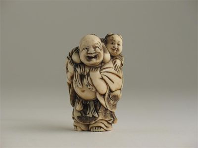 Appraisal: A Japanese ivory netsuke carved as a figure carrying a