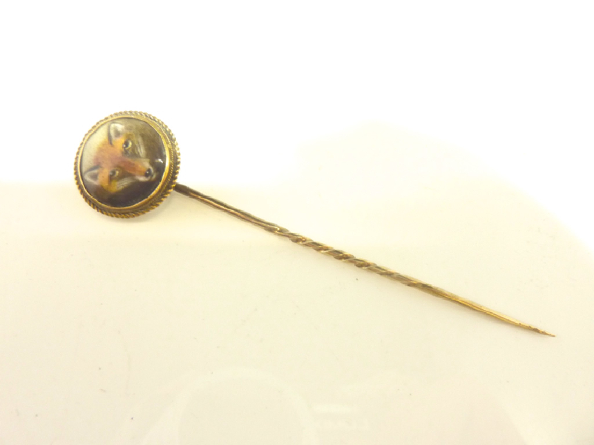 Appraisal: A Victorian stick pin terminating with a ceramic plaque painted