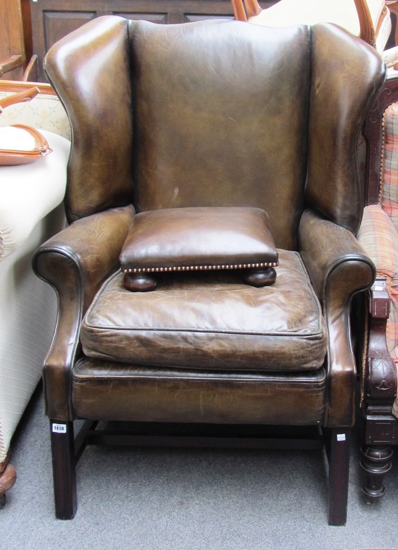 Appraisal: A mid th century style green leather upholstered wingback armchair