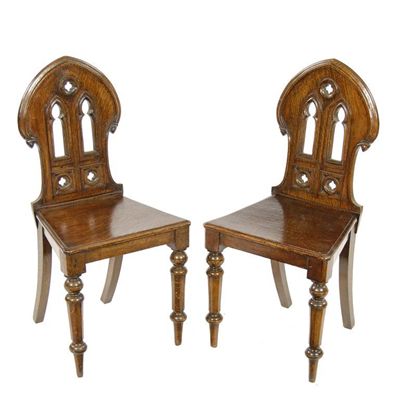 Appraisal: A pair of Victorian oak hall chairs the shaped backs