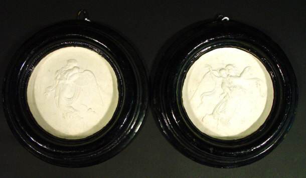 Appraisal: Two circular plaster plaques relief moulded with angels and cherubs